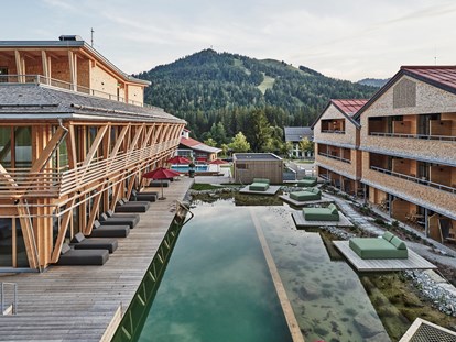 Mountainbike Urlaub - Pools: Infinity Pool - Außenansicht des Mountain Spring Spa  mit Naturbadesee - HUBERTUS Mountain Refugio Allgäu
