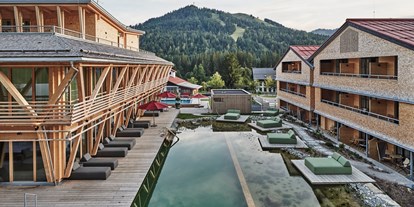 Mountainbike Urlaub - Pools: Schwimmteich - Bad Hindelang - Außenansicht des Mountain Spring Spa  mit Naturbadesee - HUBERTUS Mountain Refugio Allgäu