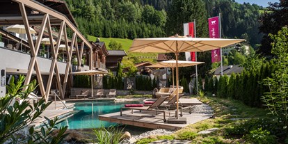 Mountainbike Urlaub - Pools: Außenpool nicht beheizt - Mayrhofen (Saalfelden am Steinernen Meer) - Außenansicht vom Hotel mit Naturpool - Wander- & Wellnesshotel Gassner