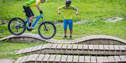 Mountainbike Urlaub - Niederdorf (Trentino-Südtirol) - In Zusammenarbeit mit der MTB Schule St. Ulrich und ihren professionellen MTB Guides bieten wir täglich geführte Touren und auf Anfrage auch Fahrtechnikkurse im Trainings-Park. Außerdem Verleih von MTB und Ebikes der neuesten Generation. - Alpenheim  Charming Hotel & Spa Hotel