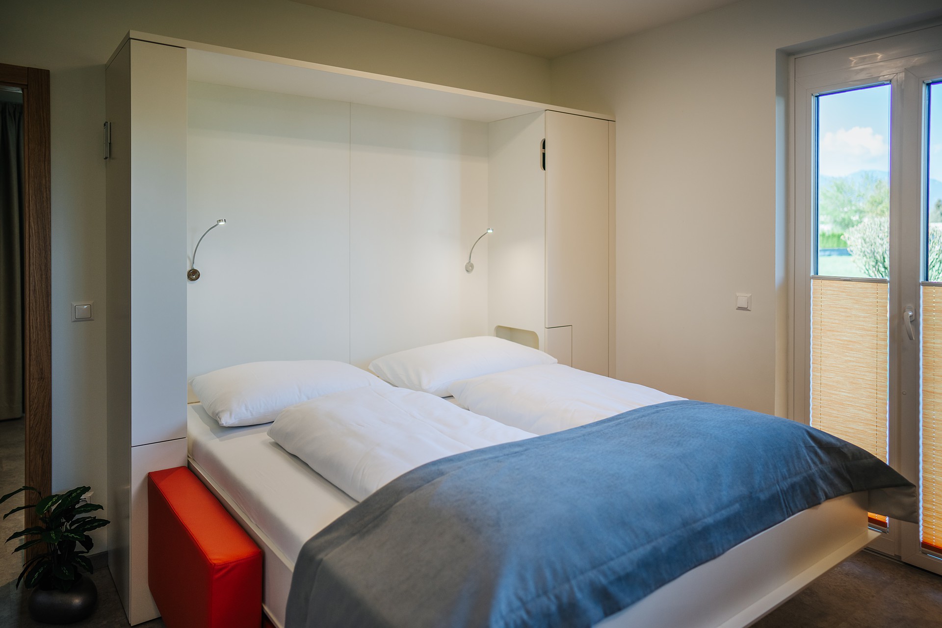 Mountainbikehotel: Wohnzimmer mit frei schwebendem Schrankbett - Ferienwohnungen und Seebungalows am Faaker See - Karglhof OG