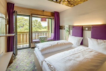 Mountainbikehotel: Trendige Design-Zimmer mit vielen Ablageflächen und Sitzbank im Panoramafenster. - Explorer Hotel Kitzbühel