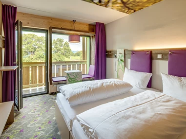Mountainbikehotel: Trendige Design-Zimmer mit vielen Ablageflächen und Sitzbank im Panoramafenster. - Explorer Hotel Bad Kleinkirchheim